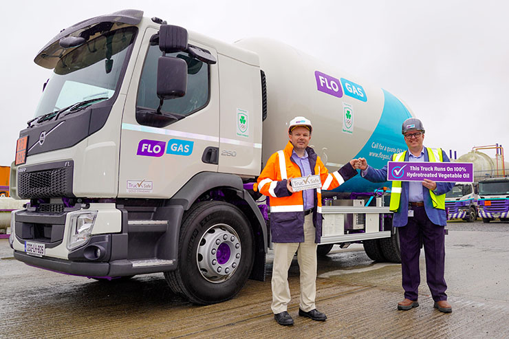 Flogas team members stand in front of a Flogas truck with a sign saying 'This truck runs on 100% hydrogenated vegetable oil'